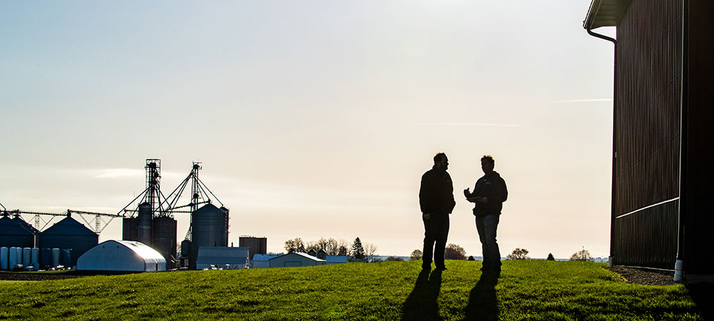 Two men talking outside in a shadow